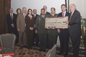 In December, Capt. Ronald Iammartino, USA (3rd from r), commander, Headquarters Command, accepts a check for $6,000 on behalf of the Holiday Helper Program. Maj. Gen. Dennis L. Via, USA (c), commander, U.S. Communications and Electronics Command Life Cycle Management Command, and members of the Combined Professional Association presented the check to Capt. Iammartino.